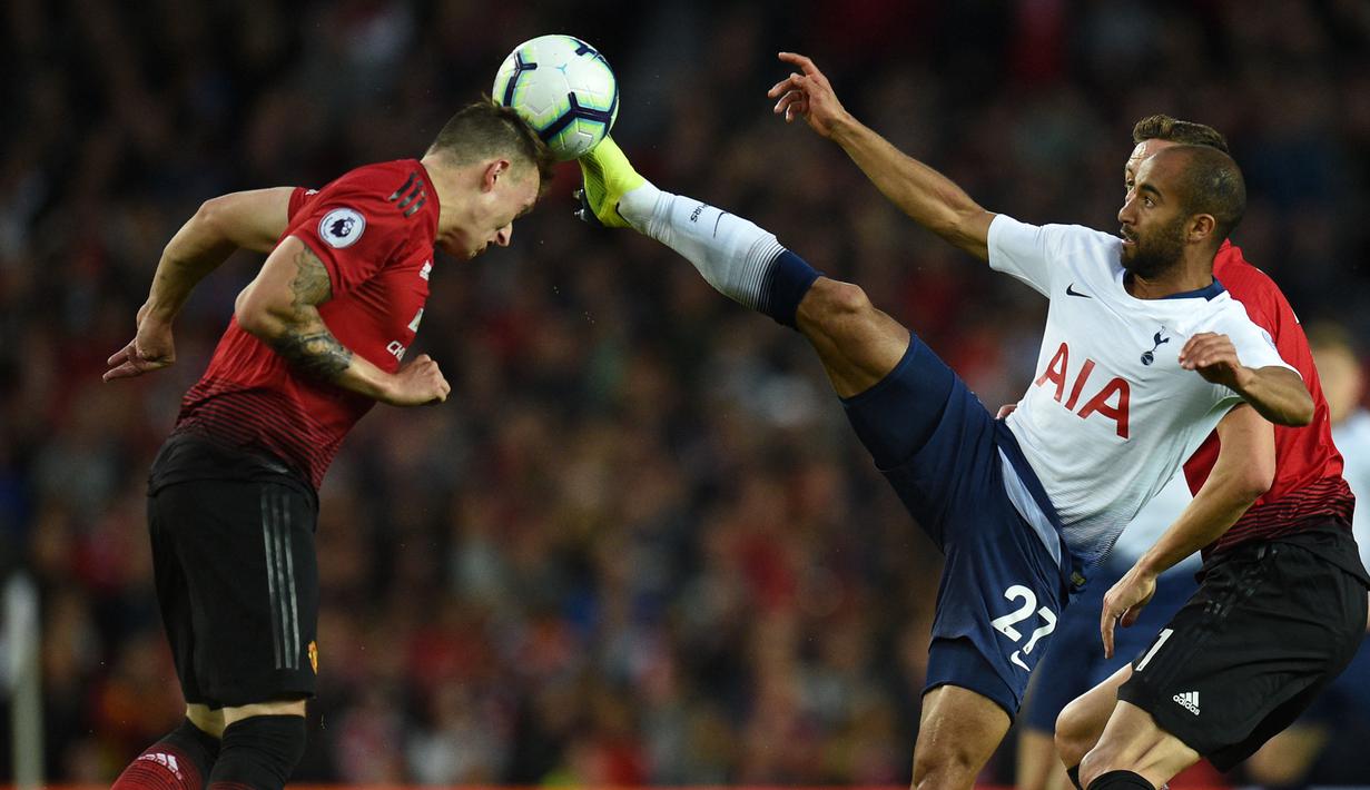 Pemain Tottenham Hotspur, Lucas Moura (kanan), berebut bola dengan menggunakan kakinya yang mengenai kepala dari pemain Manchester United, Phil Jones (kiri) dalam pertandingan Liga Inggris 2018/2019 di Old Trafford, Senin (27/8/2018). (AFP/Oli Scarff)