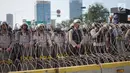 Aparat kepolisian berjaga di balik barikade kawat berduri saat unjuk rasa massa aksi dari elemen di depan Gedung DPR RI, Jakarta, Senin (30/9/2019). Aksi unjuk rasa tersebut menyikapi penolakan terhadap UU KPK dan sejumlah RUU yang dinilai bermasalah. (Liputan6.com/Immanuel Antonius)