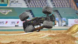 Truk monster terguling saat melewati rintangan selama pertunjukan Monster Jam di stadion Raja Fahad, Riyadh, Arab Saudi, Jumat (17/3). Acara ini diselenggarakan General Entertainment Authority. (AFP Photo/Fayez Nureldine)