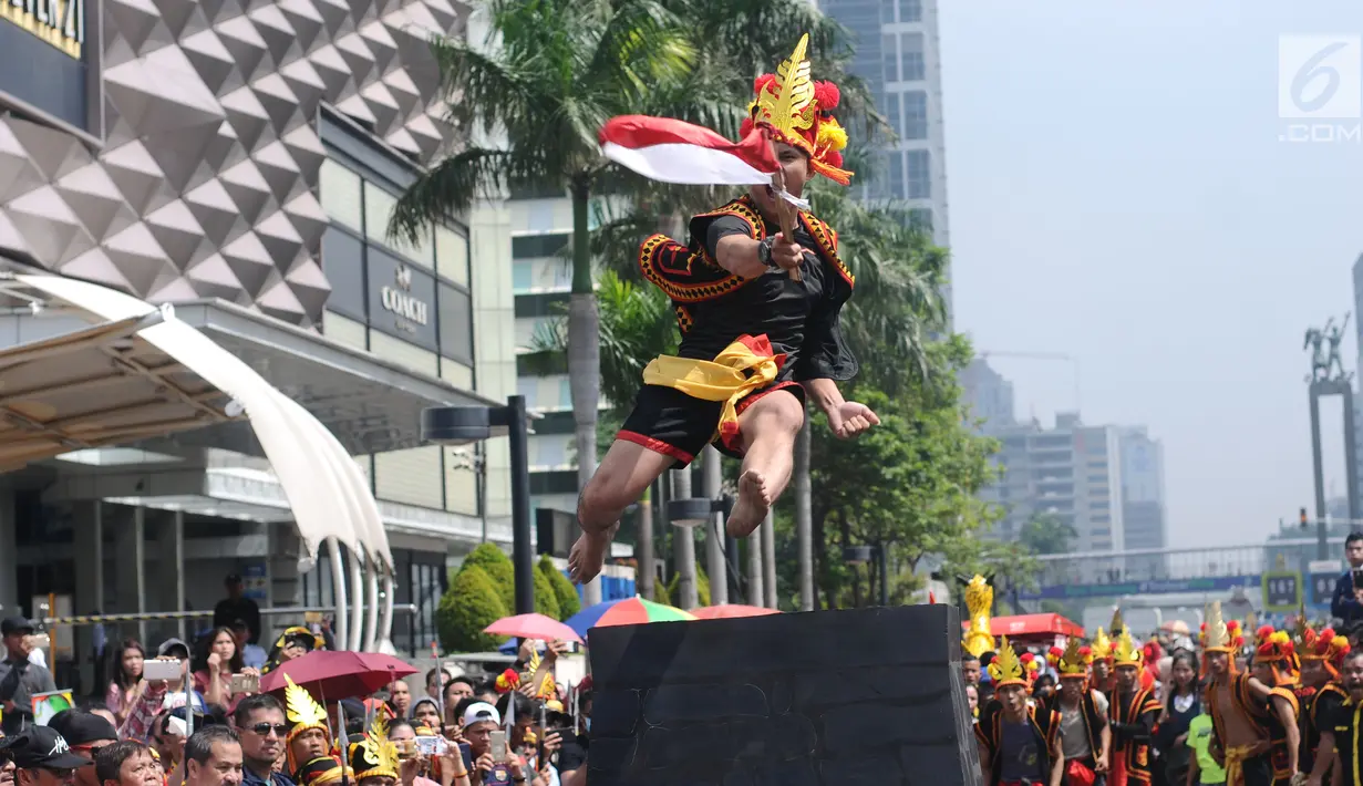 Salah satu pemuda peduli Nias melakukan atraksi lompat batu di kawasan Jalan Jenderal Sudirman, Jakarta, Minggu (4/3). Pemuda Peduli Nias melakukan beragam atraksi budaya untuk mempromosikan pariwisata di pulau tersebut. (Liputan6.com/Helmi Fithriansyah)