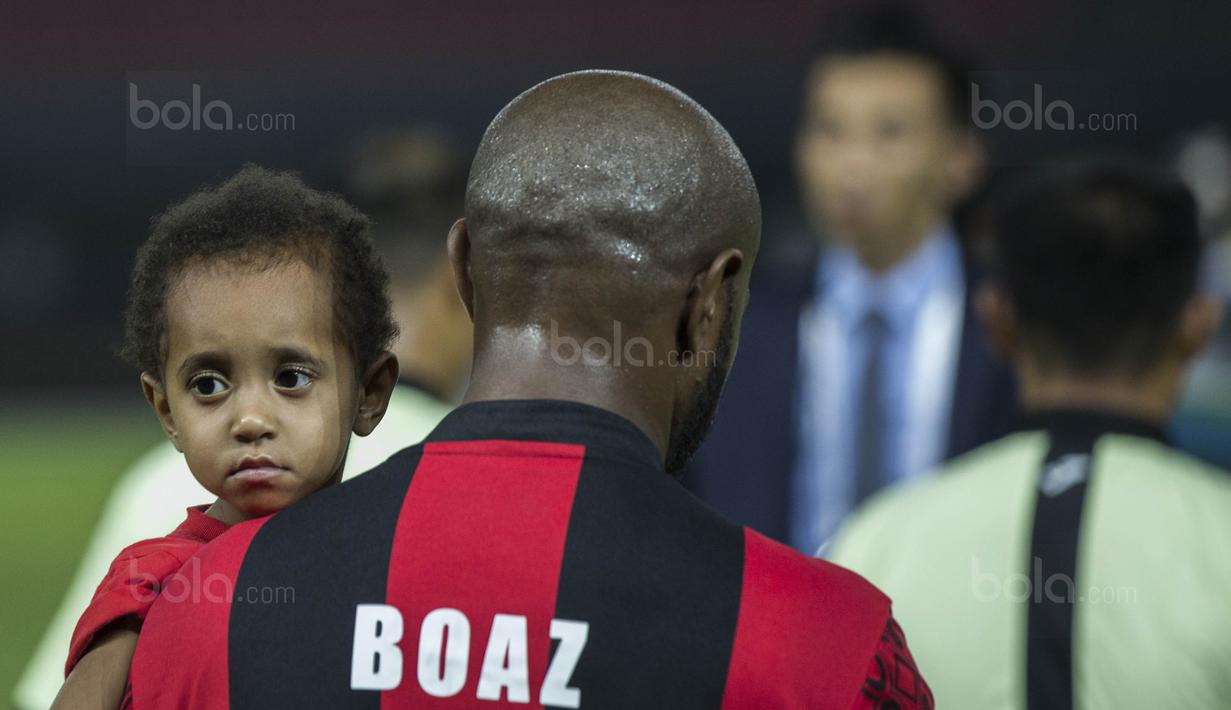 Kapten Persipura, Boaz Solossa, menggendong sang putri sebelum bertanding melawan Bhayangkara FC pada laga Liga 1 Indonesia di Stadion Patriot, Bekasi, Sabtu (9/9/2017). Bhayangkara FC menang 2-1 atas Persipura. (Bola.com/Vitalis Yogi Trisna)