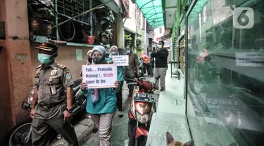 Petugas Satpol PP bersama Ibu Pembinaan Kesejahteraan Keluarga (PKK) berkeliling lingkungan membawa poster saat Operasi Yustisi di RW 01 Kelurahan Sunter Agung, Tanjung Priok, Jakarta Utara, Selasa (10/5/2022). Operasi Yustisi tersebut bertujuan mendata pendatang baru pasca Lebaran sekaligus mengimbau masyarakat untuk melengkapi dosis vaksin guna mencegah penyebaran klaster mudik. (merdeka.com/Iqbal S. Nugroho)