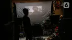 Adul (29) mengecek video di sebuah layar di gudang rumahnya di Jakarta, Rabu (28/4/2021). Sebelum masa pandemi, industri layar tancap memang perlahan mulai redup. (Liputan6.com/Johan Tallo)
