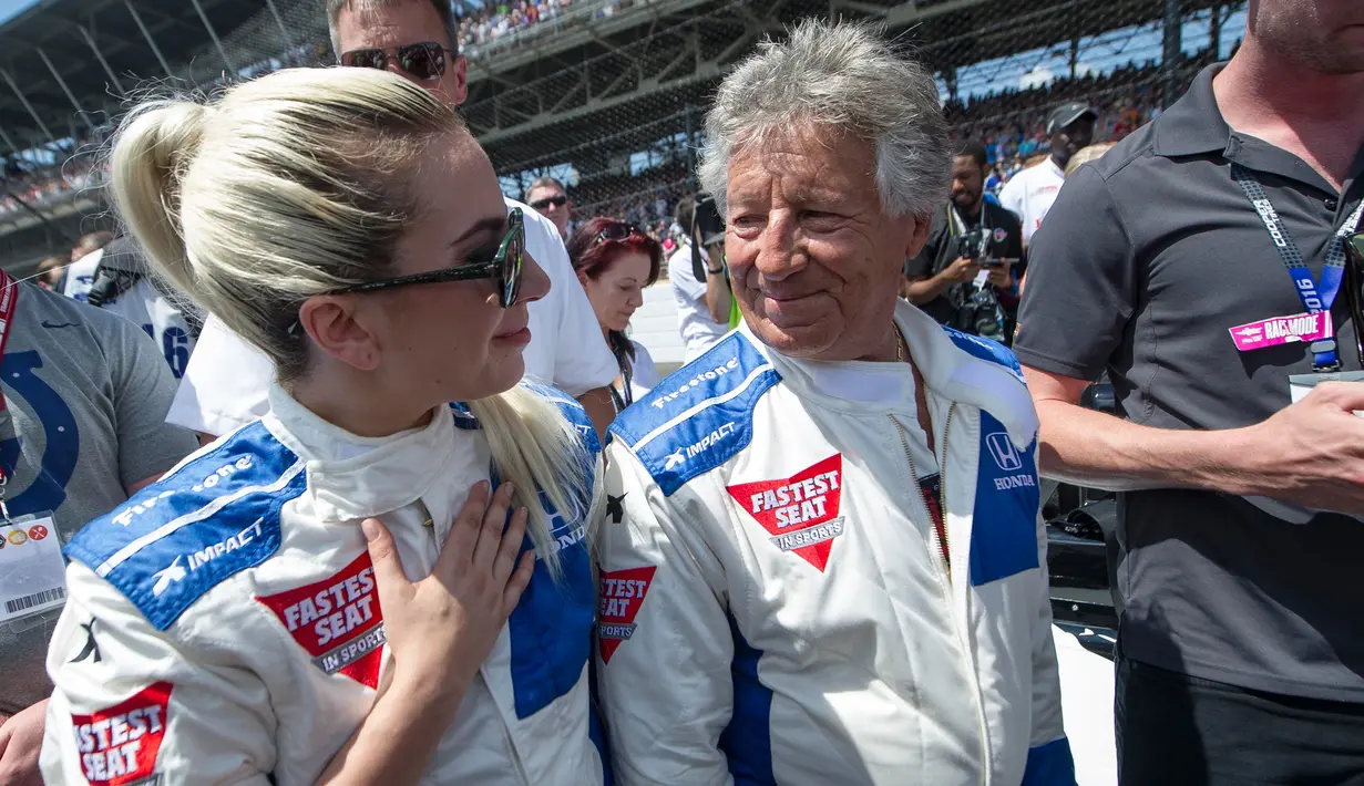 Lady Gaga berbincang dengan mantan juara Indianapolis 1969, Mario Andretti usai menjajal mobil balap dalam acara pembukaan kejuaraan Indianapolis 500 tahun 2016 di Indianapolis Motor Speedway, Amerika (29/5). (REUTERS/Thomas J. Russo-USA TODAY Sports)
