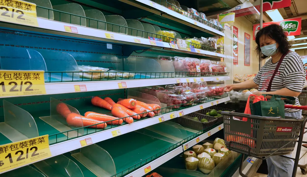 Seorang perempuan membeli makanan di supermarket untuk persiapan menghadapi Badai Tropis Kompasu di Hong Kong pada Selasa (12/10/2021). Observatorium Hong Kong mengeluarkan sinyal nomor 8, level tertinggi ketiga dalam skalanya, saat siklon tropis Kompasu semakin mendekati kota. (AP Photo/Vincent Yu)
