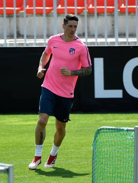 Penyerang Atletico Madrid, Fernando Torres melakukan pemanasan saat sesi latihan di Ciudad Deportiva Wanda di Madrid (2/5). Pada leg pertama Atletico Madrid bermain imbang 1-1 atas Arsenal di Emirates Stadium. (AFP Photo/Pierre-Philippe Marcou)