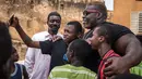 Iron Biby berfoto dengan warga setempat di kota kelahirannya, Bobo-Dioulasso di Burkina Faso pada 24 September 2018. Dulu, Iron Biby adalah korban bullying karena ukuran tubuhnya yang lebih besar di banding anak-anak lainnya. (OLYMPIA DE MAISMONT / AFP)