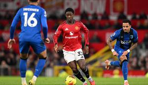 Gelandang Manchester United asal Inggris bernomor punggung 37, Kobbie Mainoo (C), berduel dengan gelandang Bournemouth asal Inggris bernomor punggung 16, Marcus Tavernier (L), selama pertandingan Liga Inggris antara Manchester United dan Bournemouth di Old Trafford, Manchester, barat laut Inggris, Selasa (16-12-2025) dini hari WIB. (PETER POWELL/AFP)