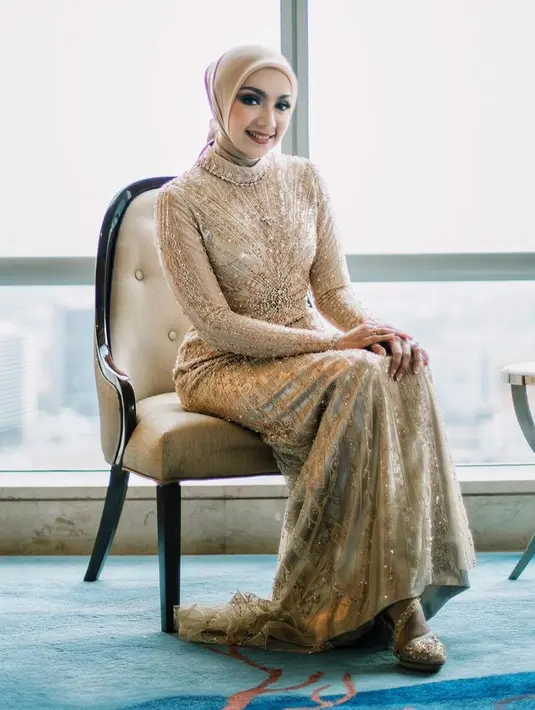 Dress hijab warna gold dengan taburan payet yang mewah kakak ipar Jessica Mila Emmy Alaydrus rancangan Studioboh.  [Foto: Instagram @emmyalaydrus]