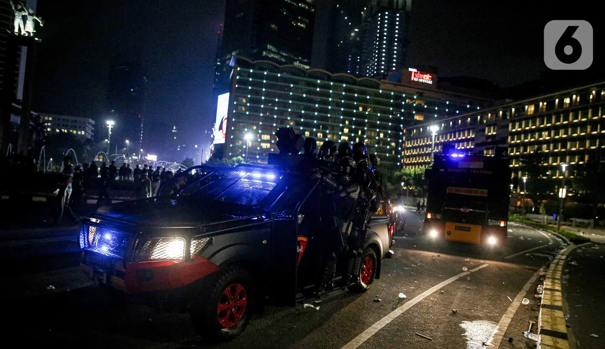 Mobil polisi lalu-lalang usai demonstrasi yang berujung anarkis di kawasan Bundaran HI, Jakarta, Kamis (8/10/2020). Massa membakar sejumlah barang saat demonstrasi menolak pengesahan UU Cipta Kerja. (Liputan6.com/Faizal Fanani)