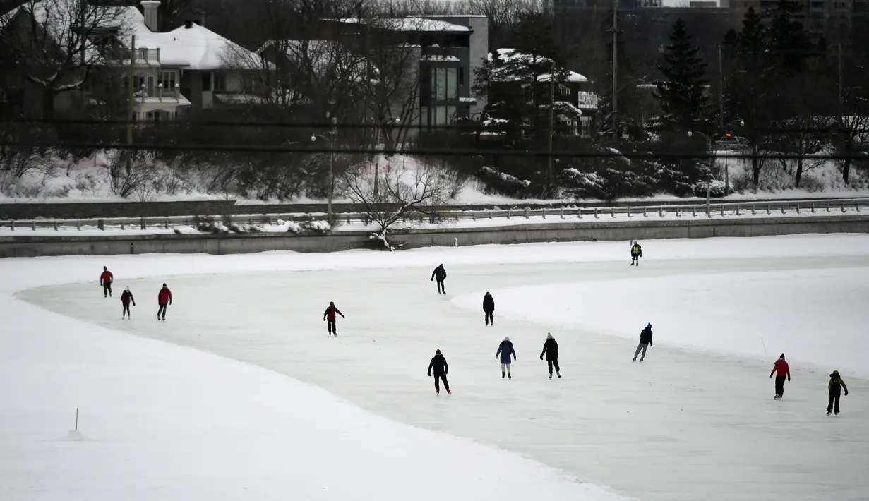 Orang-orang menyusuri Rideau Canal Skateway pada hari pembukaannya di Ottawa, Ontario, Kamis (28/1/2021). Karena pandemi, tempat konsesi, penyewaan skate dan fasilitas ganti di sepanjang skateway akan tetap ditutup, dan tidak akan ada meja piknik musim ini. (Justin Tang/The Canadian Press via AP)