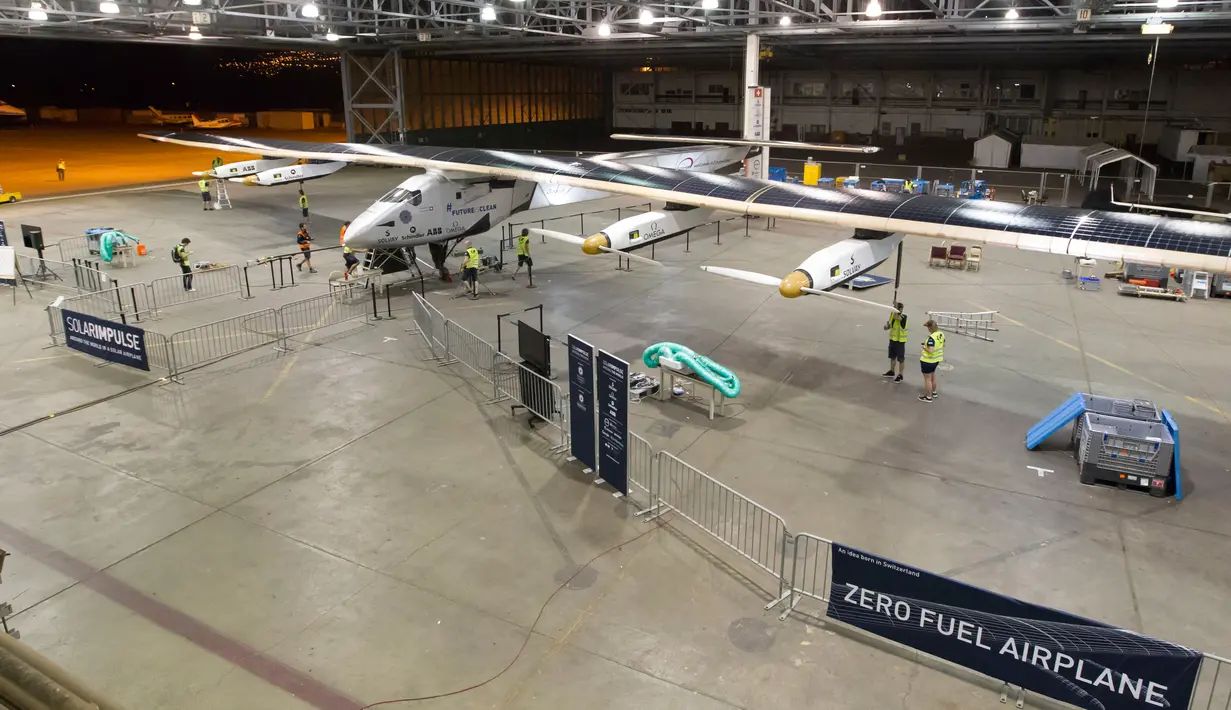 Petugas mempersiapkan pesawat bertenaga surya, Solar Impulse 2 untuk uji penerbangan di bandara Kalaeloa, Hawaii, Kamis (3/3). Pesawat ini rencananya akan melakukan perjalanan keliling dunia untuk mempromosikan energi terbarukan. (AFP PHOTO/EUGENE Tanne)