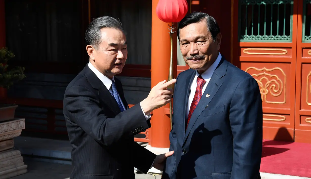 Menlu China, Wang Yi berbincang dengan Menko Kemaritiman, Luhut Pandjaitan sebelum pertemuan di Wisma Negara Diaoyutai, Beijing. Rabu (24/10). Pertemuan membahas kerja sama kedua negara antara lain di bidang kelauatan. (Daisuke Suzuki/Pool via AP)