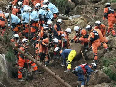 Petugas penyelamat dan polisi berusaha mencari korban usai terjadi longsor yang menghantam rumah hunian di Nakatsu, Prefektur Oita, Jepang (11/4). Sedikitnya enam orang hilang setelah tertimbun longsor. (AFP Photo/Jiji Press/Japan Out)