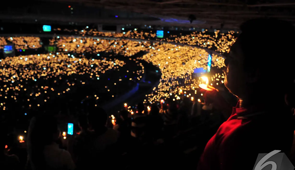 Jemaat Gereja Tiberias menyalakan lilin dalam perayaan Natal 2015 di Gelora Bung Karno, Jakarta, Sabtu (13/12/2014). (Liputan6.com/Johan Tallo)