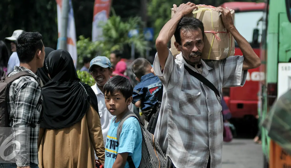 Pemudik memikul barang bawaannya saat tiba di Terminal Kampung Rambutan, Jakarta Timur, Sabtu (9/7). Puncak arus balik Lebaran diprediksi terjadi pada Sabtu- Minggu (9-10) Juli 2016. (Liputan6.com/Yoppy Renato)