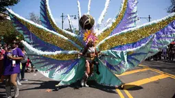 Seorang penari mengenakan kostum bulu selama ambil bagian dalam Parade West Indian Day di Brooklyn borough, New York, Senin (4/9). Parade tersebut merupakan salah satu perayaan budaya Karibia terbesar di Amerika Serikat. (AP Photo/Kevin Hagen)