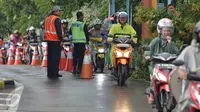 Petugas mengamati pengendara sepeda motor yang masuk menuju tol dalam kota di pintu tol Taman Mini 2, Jakarta, Kamis (21/4). Hujan deras yang mengguyur sejak semalam membuat sejumlah jalan di Ibu Kota tergenang banjir. (Liputan6.com/Angga Yuniar)