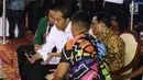 Presiden RI, Joko Widodo (kedua kiri) melihat ponsel jelang menyaksikan laga atlet para powerlifting Indonesia di kelas Womens Up 73 dan 79kg Asian Para Games 2018 di Jakarta, Rabu (10/10). (Liputan6.com/Helmi Fithriansyah)