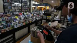 Pecinta musik memilah Piringan Hitam, CD, dan Kaset pita di toko "Wow Record Store", Blok M Squere, Jakarta, Jumat (12/3/2021). Dengan begitu jumlah minat pembeli Piringan Hitam, CD, dan Kaset Pita ini menurun secara offline. (Liputan6.com/Johan Tallo)