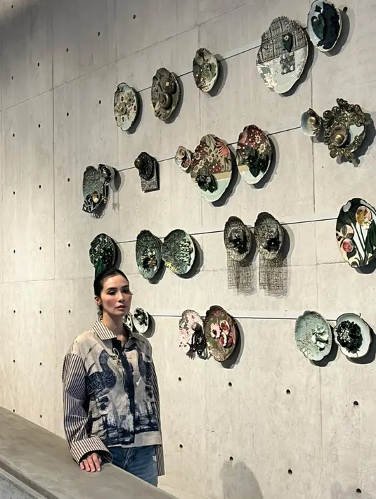 Dibentuk oleh tangan, presisinya api dan kelembutan benang. Berpadu satu menjadi pajangan yang memikat. Marsha Timothy tampak terpukau dengan karya piring porselen nan cantik yang menjadi pajangan dinding estetik. / Foto dok: Fimela.