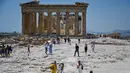 Wisatawan mengunjungi Acropolis di Athena, Yunani, Minggu (24/7/2022). Negara ini berada dalam cengkeraman gelombang panas yang dimulai pada 23 Juli dan akan berlangsung beberapa hari. Suhu diperkirakan akan mencapai 42 derajat Celcius (107 derajat Fahrenheit) di beberapa daerah.
(Louisa GOULIAMAKI / AFP)