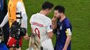 Penyerang Polandia #09 Robert Lewandowski dan penyerang #10 Argentina Lionel Messi saling menyapa pada akhir matchday pamungkas Grup C Piala Dunia 2022 di 974 Stadium, Kamis (1/12/2022) dini hari WIB. Hingga berita ini diturunkan, belum ada pernyataan dari kedua pemain. (Glyn KIRK / AFP)