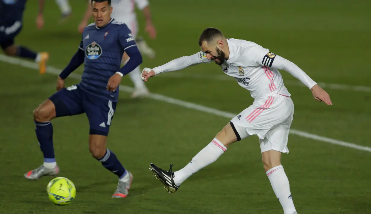 Striker Real Madrid, Karim Benzema menembak bola saat bertanding melawan Celta Vigo pada lanjutan La Liga Spanyol di stadion Alfredo Di Stefano, Minggu (3/1/2021). Real Madrid,  menggeser Atletico Madrid yang punya 35 poin, namun masih menyimpan tabungan tiga laga.(AP Photo/Manu Fernandez)