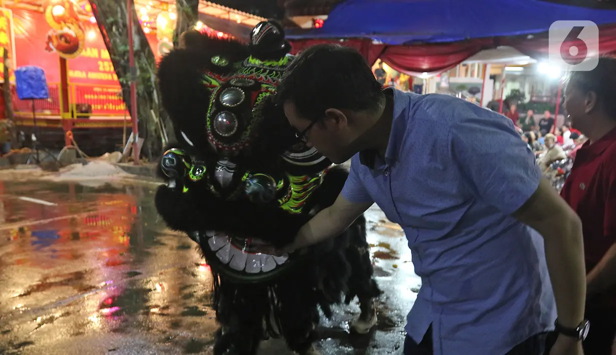 Warga memberikan angpao seusai sembahyang menyambut tahun baru Imlek di Vihara Amurva Bhumi, kawasan Karet Semanggi, Jakarta, Jumat (24/1/2020). Vihara yang berada di Jalan Dr Satrio ini, menjadi salah satu lokasi warga tionghoa menyambut pergantian tahun. (Liputan6.com/Herman Zakharia)