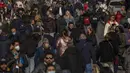 Orang-orang, beberapa dari mereka tanpa masker, berjalan di sepanjang jalan di pusat kota Madrid, Kamis (10//2/2022). Warga Spanyol untuk pertama kalinya dalam hampir dua bulan diperbolehkan tidak menggunakan masker di luar ruangan setelah peraturan terkait hal itu dicabut. (AP Photo/Manu Fernandez)