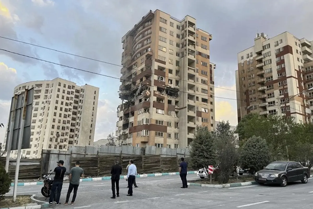 Warga mengamati apartemen yang rusak di Teheran, Iran, akibat serangan udara Israel pada Jumat (13/6/2025).