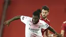 Gelandang AC Milan, Franck Kessie membawa bola dari kawalan gelandang Manchester United, Bruno Fernandes pada pertandingan leg pertama babak 16 besar Liga Europa di Old Trafford, Inggris, Jumat (12/3/2021). MU bermain imbang atas AC Milan 1-1. (AP Photo/Dave Thompson)