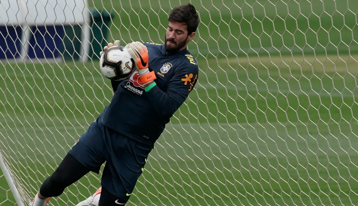 Kiper Brasil, Alisson berusaha menangkap bola saat mengikuti latihan di pusat pelatihan Granja Comary di Teresopolis, Brasil (6/7/2019). Brasil akan bertanding melawan Peru pada babak final Copa America 2019. (AP Photo/Leo Correa)