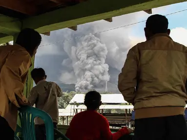 Warga desa berkumpul menyaksikan gunung berapi Gunung Sinabung yang memuntahkan abu tebal di Karo, Sumatra Utara (18/12). Gunung Sinabung kembali aktif pada tahun 2010 untuk pertama kalinya dalam 400 tahun. (AFP Photo/Ivan Damanik)