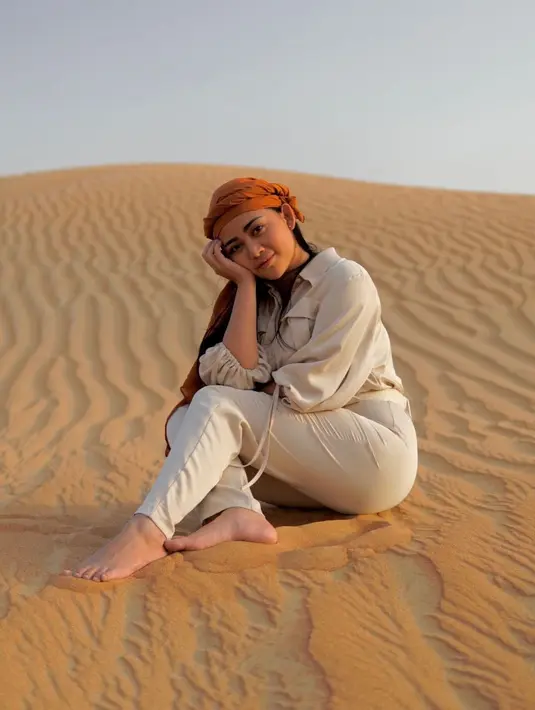 Rachel Vennya juga sempat mengunjungi padang pasir Dubai di tahun 2021. Di sini, ia tampil begitu menawan dengan balutan outfit cokelat muda dan sorban berwarna mustard yang serasi. [Foto: Instagram/rachelvennya]