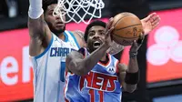 Kyrie Irving lakukan layup saat Brooklyn Nets kalahkan Charlotte Hornets pada laga lanjutan NBA, Jumat (02/04/2021) pagi WIB. (SARAH STIER / GETTY IMAGES NORTH AMERICA / GETTY IMAGES VIA AFP)