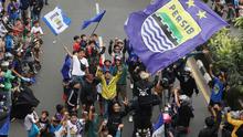 Para pendukung Persib Bandung yang dikenal dengan sebutan bobotoh melakukan pawai di Kota Bandung, Sabtu (1/6/2024) untuk menyambut kedatangan skuad Persib Bandung usai menjadi juara Championship Series BRI Liga 1 2023/2024. (Bola.com/M Iqbal Ichsan)