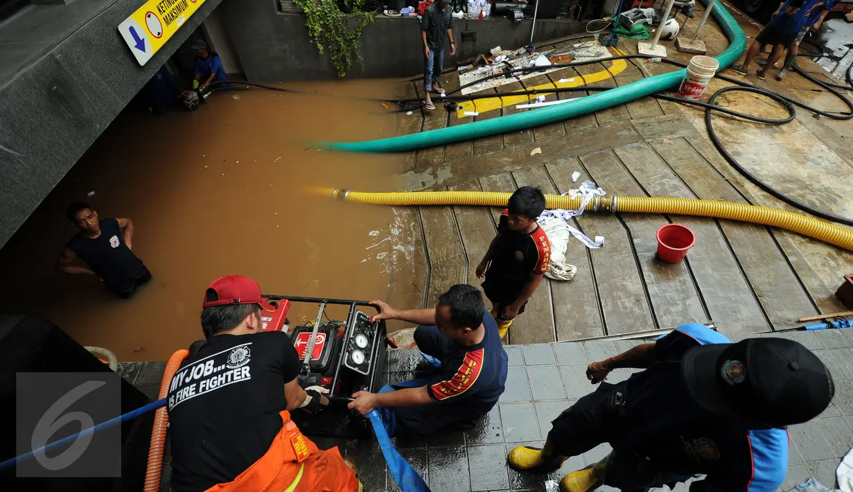 Petugas Damkar PB menyalakan mesin penyedot air saat melakukan pengeringan di salah satu pertokoan di Jalan Kemang Raya, Jakarta, Minggu (28/8). Dua lokasi parkir bawah tanah pertokoan di kawasan Kemang terendam air. (Liputan6.com/Helmi Fithriansyah)