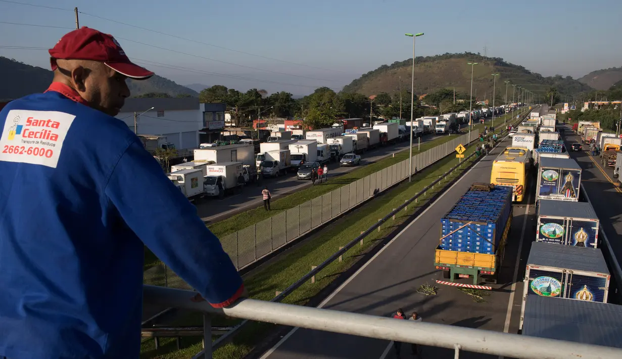 Pengemudi truk memblokir sebagian jalan, yang menghubungkan Rio de Janeiro dan Teresopolis, di Guapimirim, Brasil, Rabu (23/5). Mereka memprotes kenaikan harga solar yang terus naik selama setahun terakhir karena harga minyak dunia naik. (AP/Leo Correa)
