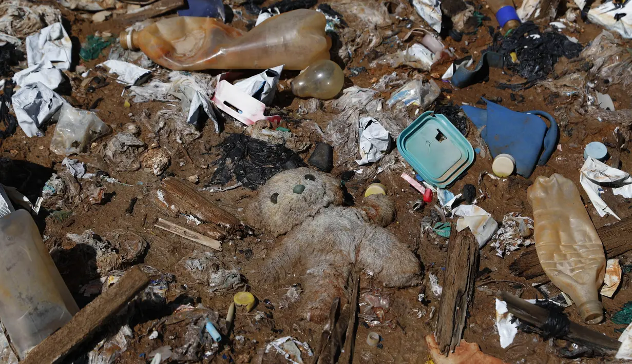 Beruang teddy terbaring di antara sampah yang menutupi bagian yang kering dari Danau Uru Uru di dekat Oruro, Bolivia, Kamis (25/3/2021). Sebagian besar area danau ini, terutama yang kering, tertutupi botol plastik dan aneka sampah lainnya. (AP Photo / Juan Karita)