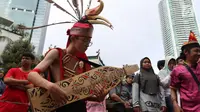 Seorang pria memainkan alat musik tradisional saat CDF di Jakarta, Minggu (28/1). Tarian tersebut dilakukan dalam rangka festiival etnik Tabalong agar masyarakat mengenal tarian yang berasal dari  Kalimantan Selatan tersebut. (Liputan6.com/Angga Yuniar)