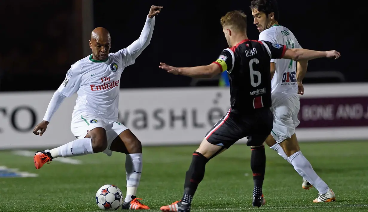 Pemain NY Cosmos, Marcos Senna (kiri) dan Raul Gonzalez menghadang pemain Ottawa Fury, Richie Ryan (tengah) pada laga Final NASL Championship di Hempstead, New York,Minggu(15/11/2015) . (AFP Photo/Don Emmert)