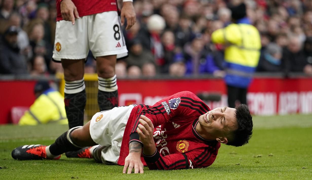 Pemain Manchester United, Lisandro Martinez tergeletak sambil mengeram kesakitan saat laga lanjutan Liga Inggris 2023/2024 antara Manchester United melawan West Ham United di Old Trafford, Manchester, Inggris, Minggu (04/02/2024). (AP Photo/Dave Thompson)