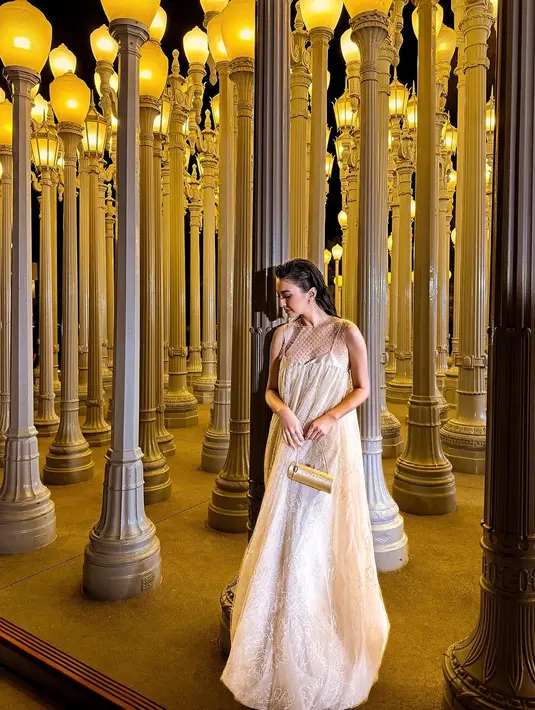 Inspirasi baju kondangan di malam hari. Sebuah dress panjang tanpa lengan bernuansa cokelat keemasan yang membalut tubuh Raline Shah dengan amat baik ini bisa ditiru loh, Sahabat FIMELA. [Foto: Instagram/ralineshah]