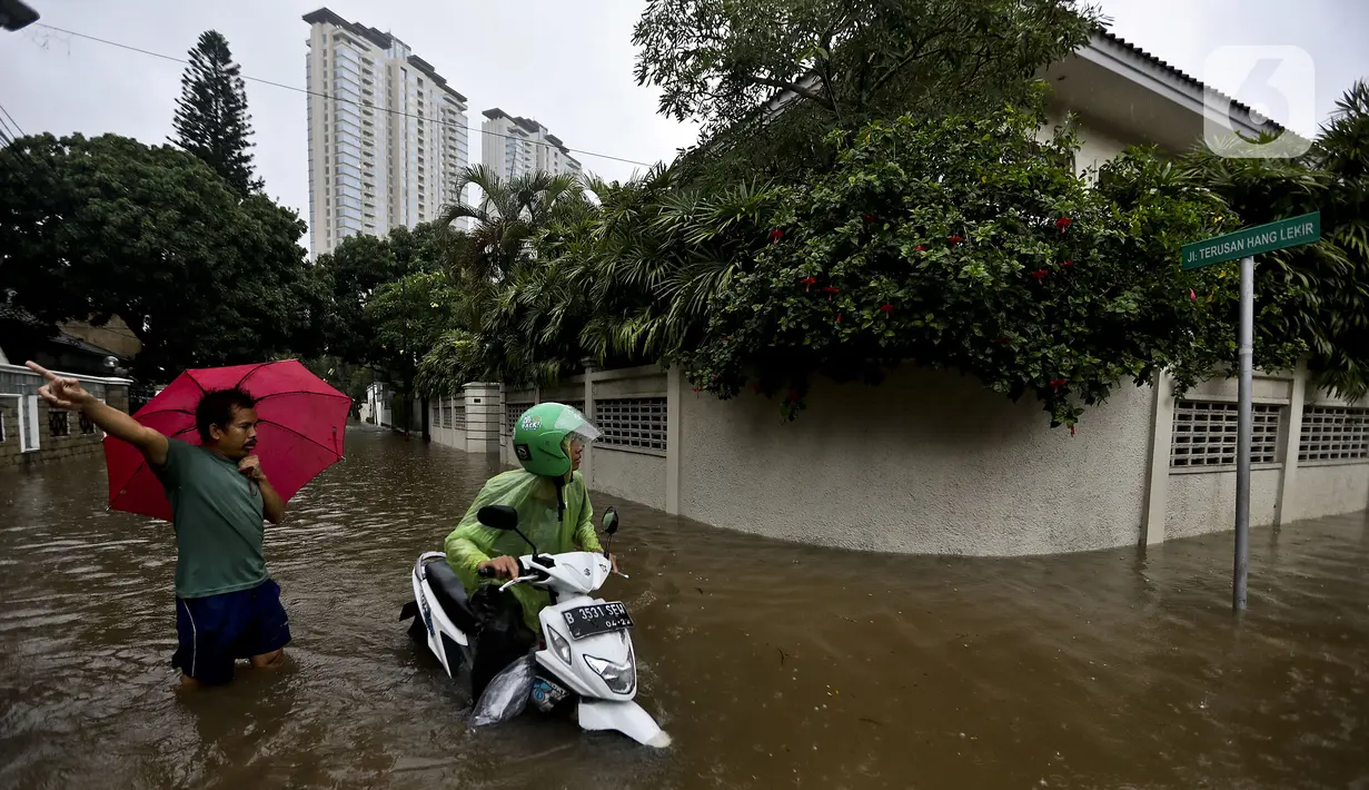 Pengendara motor melintasi banjir di Jalan Hang Lekir, Kebayoran Lama, Jakarta Selatan, Rabu (1/1/2020). Banjir tersebut disebabkan karena tingginya intensitas hujan yang mengguyur sejak Selasa (31/12/2019). (Liputan6.com/Johan Tallo)