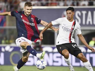 Pemain AC Milan, Tijjani Reijnders, berebut bola dengan pemain Bologna, Stefan Posch, pada pekan pertama Serie A di Stadion Renato Dall'Ara, Selasa (22/8/2023). AC Milan menang dua gol tanpa balas. (Massimo Paolone/LaPresse via AP)