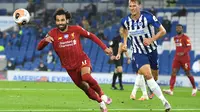 Gelandang Liverpool, Mohamed Salah, berebut bola dengan bek Brighton, Dan Burn, pada laga lanjutan Premier League pekan ke-34 di Stadion Falmer, Kamis (9/7/2020) dini hari WIB. Liverpool menang 3-1 atas Brighton. (AFP/Daniel Leal-Olivas/pool)
