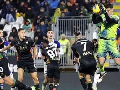 Pemain Venezia, Jay Idzes (kiri) melihat kiper Filip Stankovic berebut bola dengan pemain Hellas Verona dalam laga lanjutan Liga Italia 2024/2025 di Venice, Italia, Selasa (28/01/2025) dini hari WIB. (AP Photo/LaPresse/Paola Garbuio)