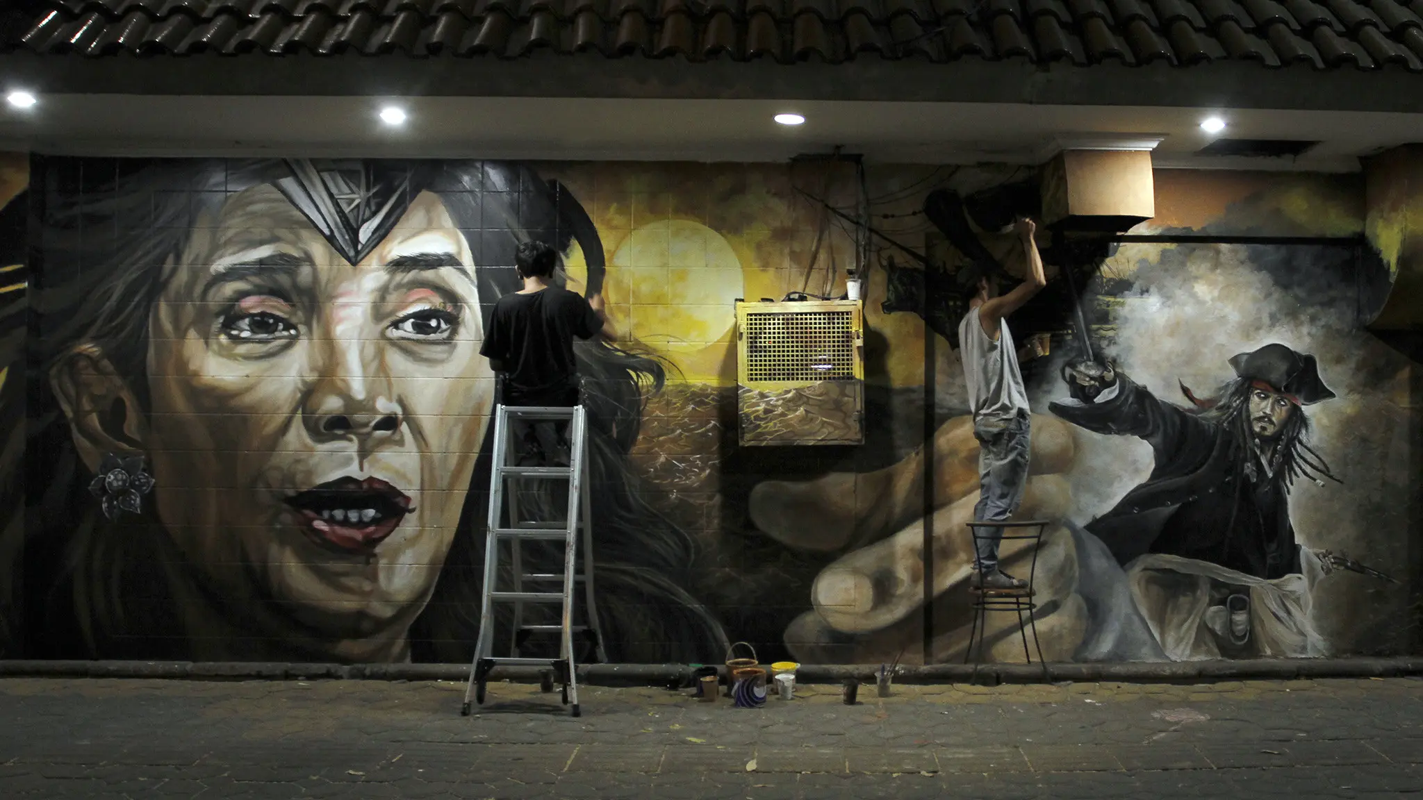 Sejumlah pelukis di Solo menggambar mural Menteri Kelautan dan Perikanan Susi Pudjiastuti bergaya Wonder Woman di tembok di Jalan Slamet Riyadi Solo, Jumat dini hari (18/8).(Liputan6.com/Fajar Abrori)