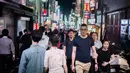 Foto yang diambil pada 22 September 2018 menunjukkan orang-orang berjalan di distrik Shinjuku, Tokyo. Distrik Shinjuku dikenal sebagai kawasan perbelanjaan dan hiburan malam Jepang. (AFP PHOTO / Martin BUREAU)